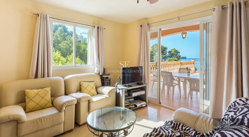 Bright interior with large windows, light wood flooring, and modern furniture. Panoramic sea views.