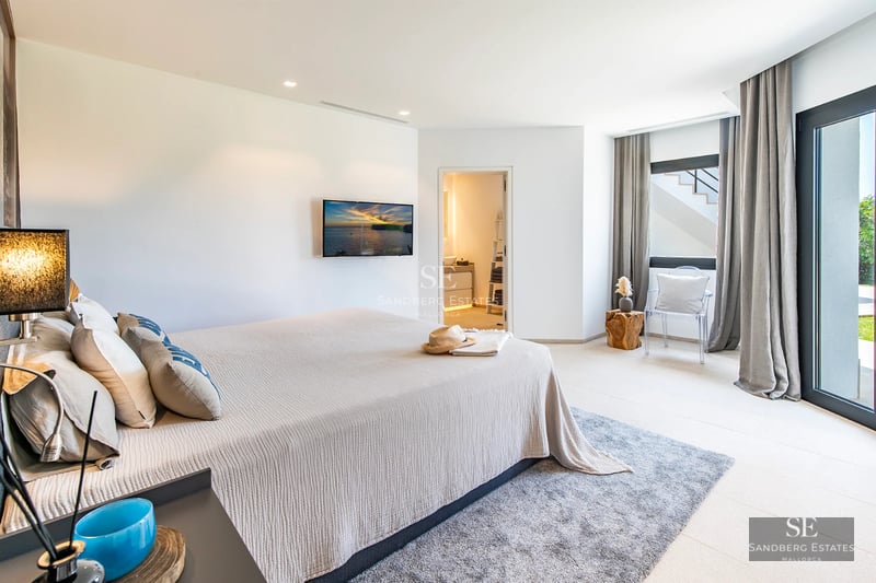 Spacious balcony with sea view, modern furniture, glass railing, wooden floor, perfect for enjoying the outdoors.