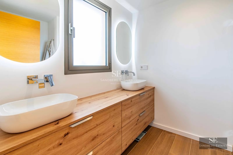 Exterior view of a modern villa featuring a pool, large windows, lush garden, and high-quality finishes.