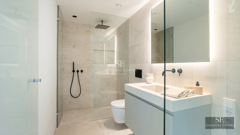 Large pool with sun loungers, surrounded by lush vegetation. Modern architecture with large windows. Luxurious and relaxing outdoor space.