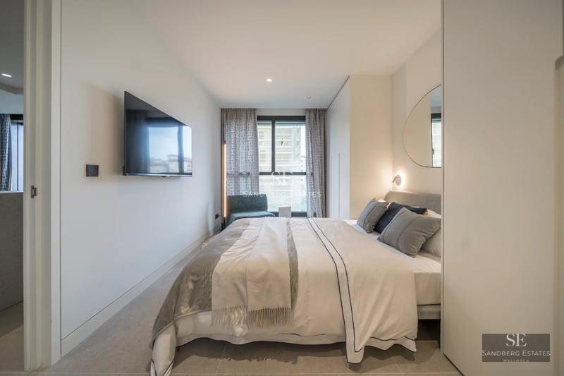 Spacious living room with fireplace, large windows and modern furniture. Wooden floors and design details. Abundant natural light.