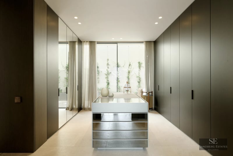 Spacious living room featuring floor-to-ceiling windows, light wood floors, modern fireplace, and designer sofas. Panoramic views.