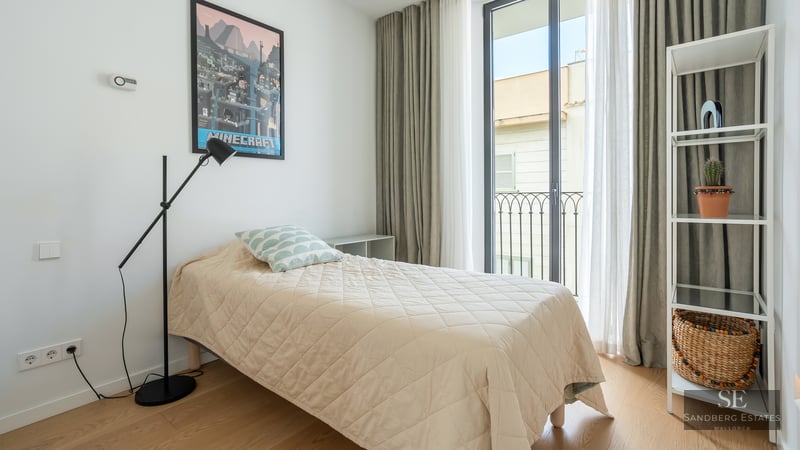 Bright bedroom with single bed, Minecraft poster, black floor lamp, and glass balcony door.