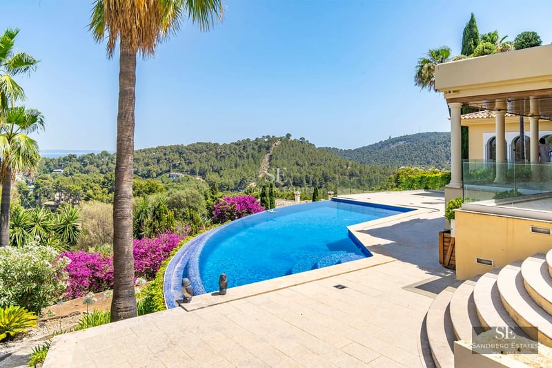 Spacious garden featuring a pool, lush vegetation, and modern architecture. Warm lighting, ideal for relaxation and outdoor living.