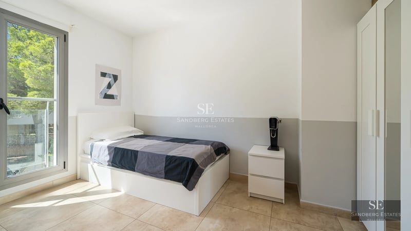 Exterior view of a modern villa with infinity pool, lush garden, and minimalist architectural design featuring large windows.