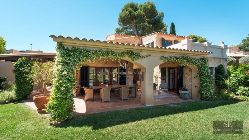 View of a modern house with a pool. Minimalist design, large windows, white facade, and lush vegetation. Natural lighting.