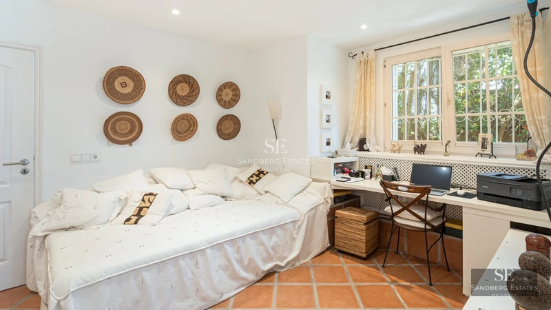 Exterior view of a modern villa featuring an infinity pool, lush garden, and expansive terraces. Minimalist architecture with large windows.