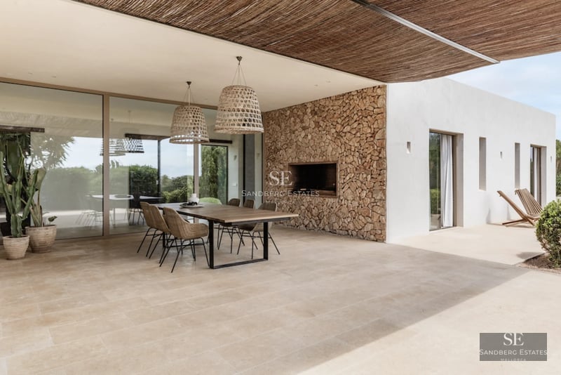 Spacious living room with fireplace, leather sofas, panoramic windows and access to a balcony with city views. Modern and elegant design.