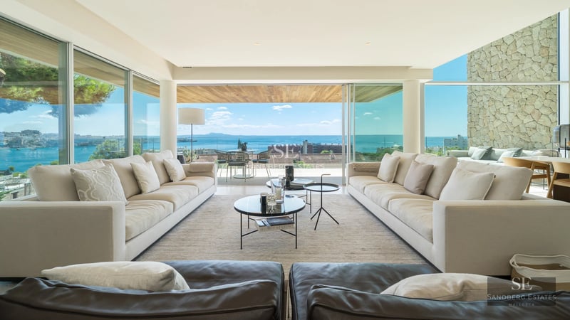 Exterior view of a modern villa with a pool, surrounded by greenery and featuring spacious outdoor living areas.