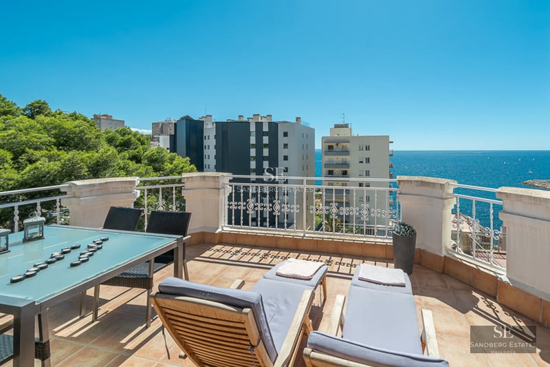 Expansive turquoise pool surrounded by lush greenery and a modern house with large windows. Relaxation and luxury.