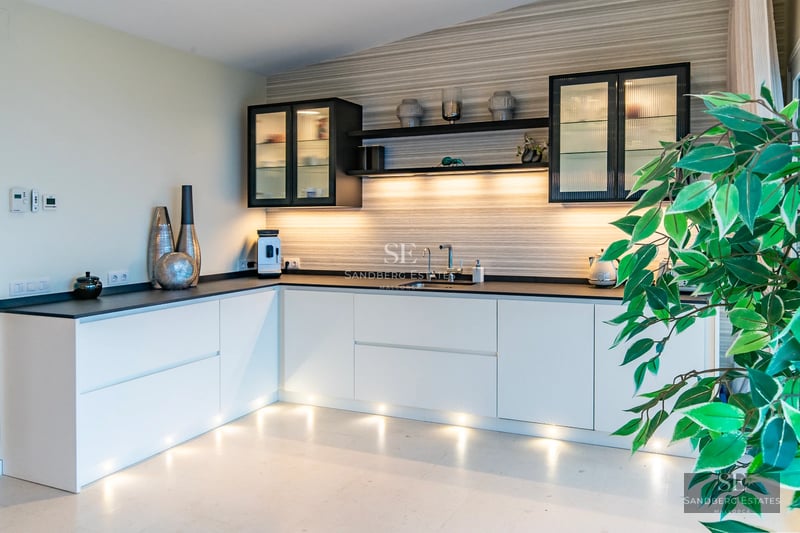 View of a modern villa with a pool. Elegant architecture, large windows, manicured landscaping. Bright facade and crystal-clear water.