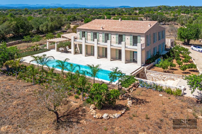 Spacious living room with large windows overlooking an infinity pool. Modern and elegant design with abundant natural light.