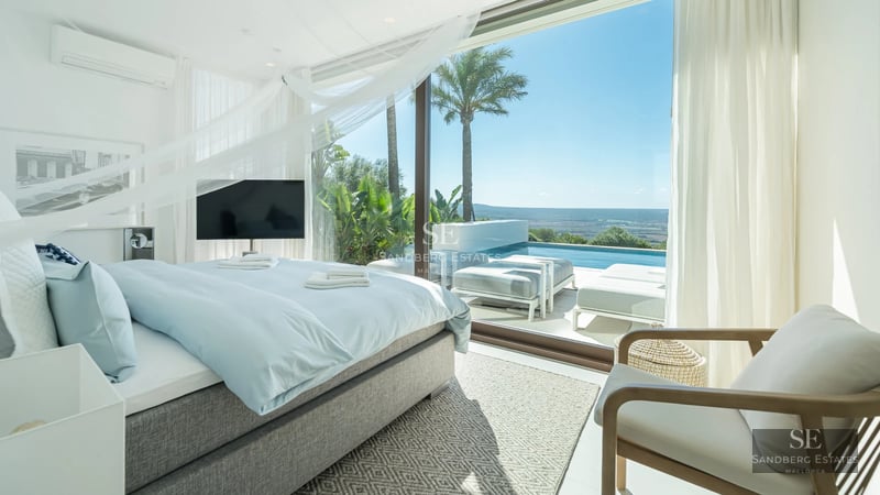 Spacious living room with panoramic windows, modern fireplace, and minimalist design. Spectacular sea views.