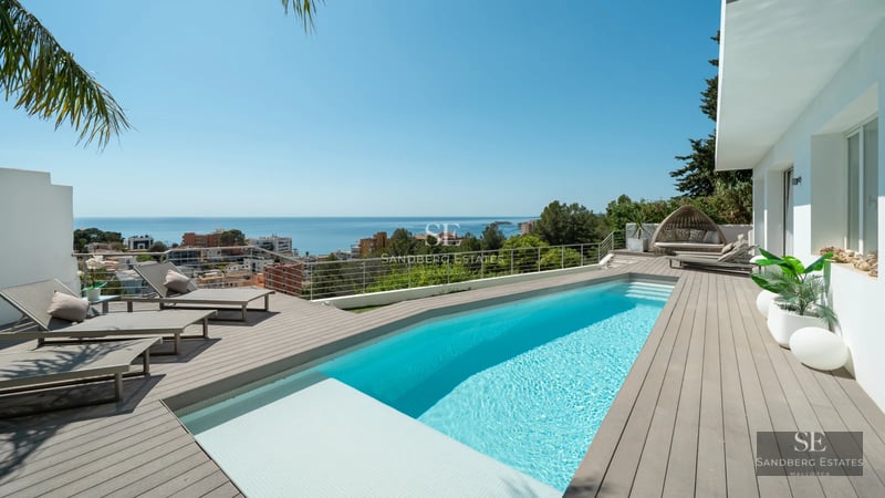 Exterior view of modern villa with pool. Minimalist architecture, large windows and lush landscaping. Ambient lighting.