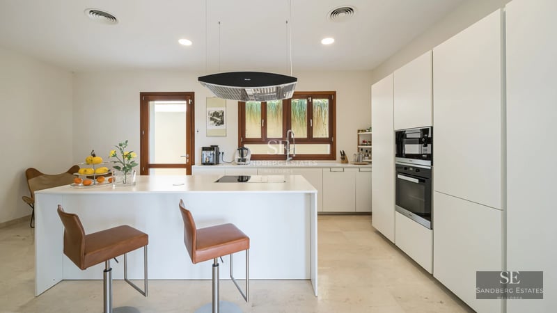 Exterior view of luxurious villa with infinity pool, modern architecture, large windows, and lush garden. Elegant and sophisticated design.