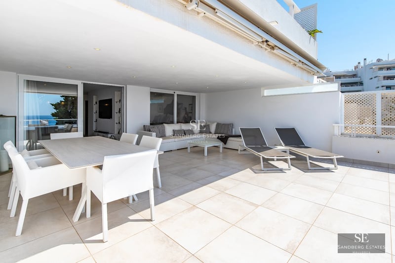 Expansive terrace with infinity pool and panoramic views. Modern architecture, sun loungers, and lush vegetation.