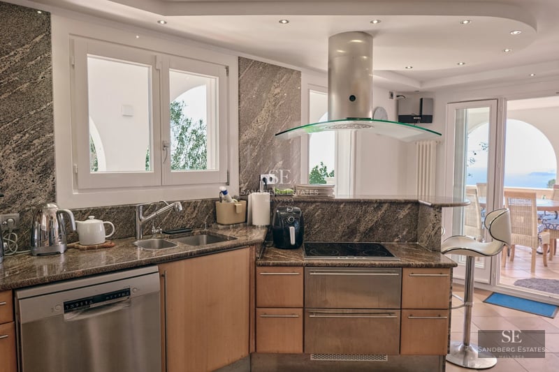 Image of a villa with a pool. Modern design featuring large windows, terrace, garden and lush vegetation. Ideal for luxury living.