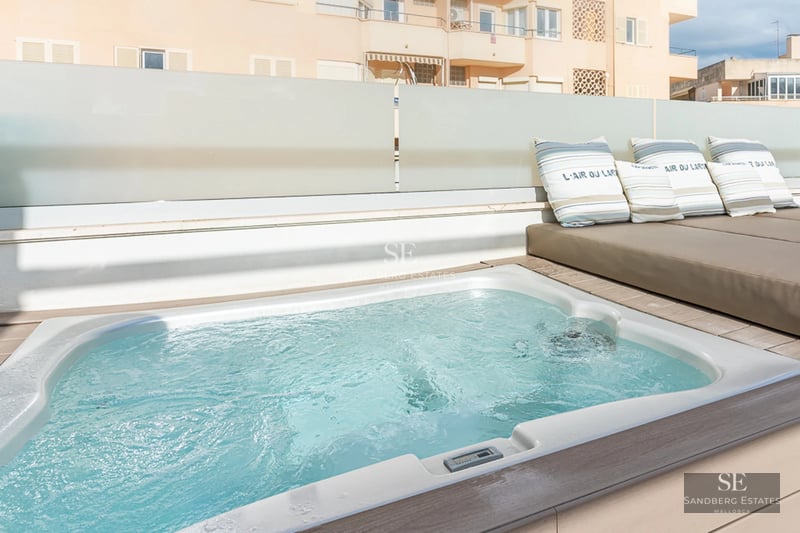 Spacious bright living room with panoramic windows, light wood floors, designer sofas and access to a terrace with panoramic views.