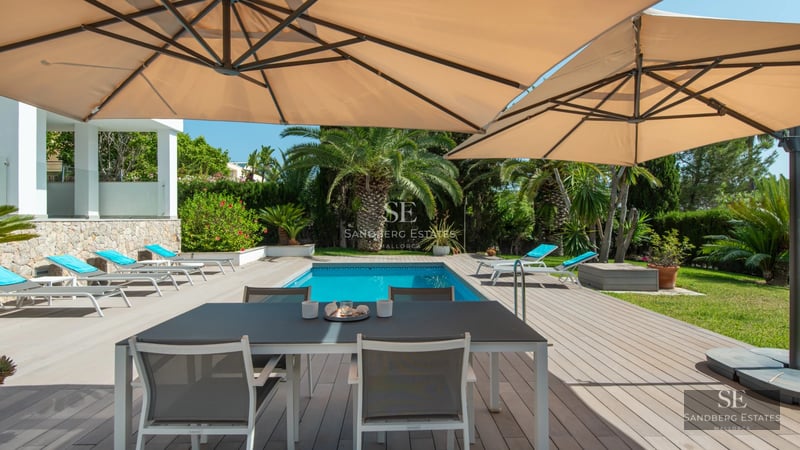 Image of a modern villa featuring an infinity pool. Minimalist design, large windows, and unobstructed views. Lush garden.