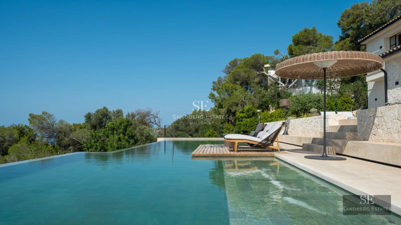 Exterior view of a modern villa with a pool, lush gardens, and elegant architecture. Soft ambient lighting.