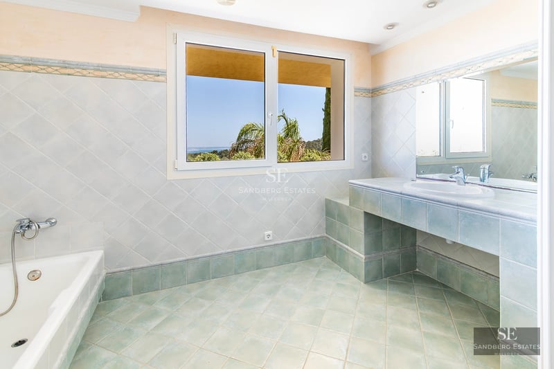 View of a luxurious villa featuring an infinity pool, lush garden, and modern architecture. Warm lighting and design details.