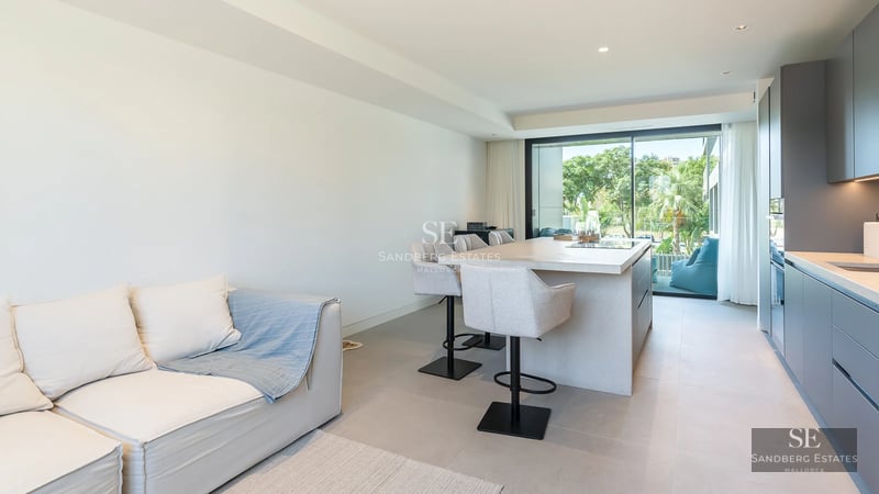 View of pool and modern house with large windows, lush greenery, and partially cloudy sky. Contemporary architecture.