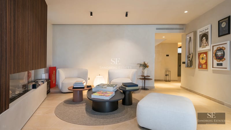 Spacious living room with panoramic sea views. Modern sofa, light wood flooring and floor-to-ceiling windows illuminate the space.