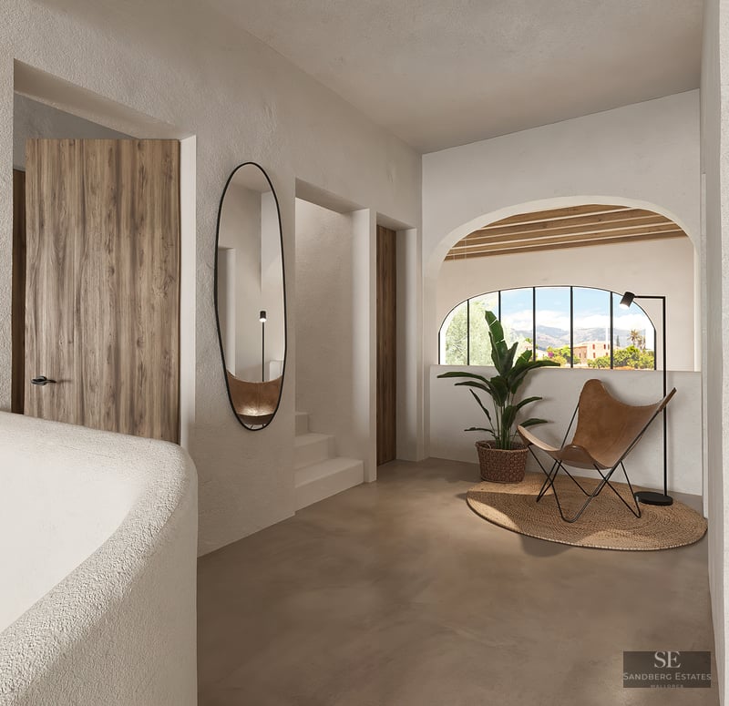 Modern hallway with textured walls, leather butterfly chair, oval mirror, and arched window with mountain views.