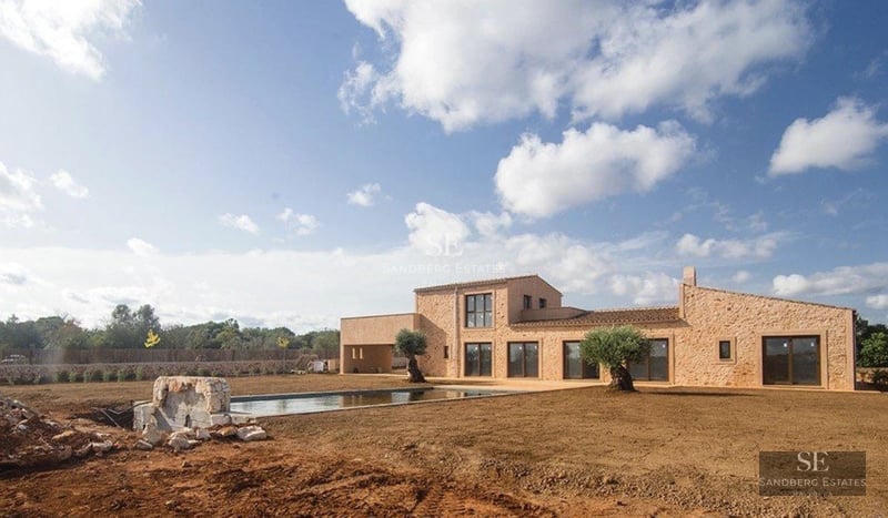 Exterior view of a modern villa with pool, surrounded by greenery. Minimalist architecture, large windows, and luxury finishes.