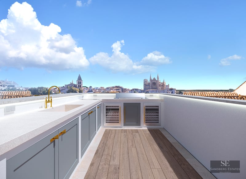 Rooftop kitchen with grey cabinets, gold faucet, and a view of a cathedral under a blue sky.