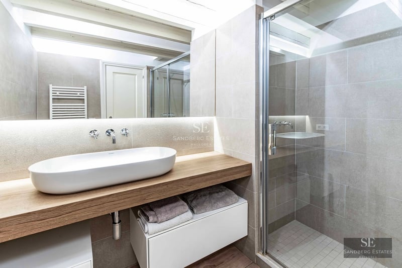 Spacious view of modern living room. Large windows illuminate the space with elegant sofas, coffee table and outdoor access.