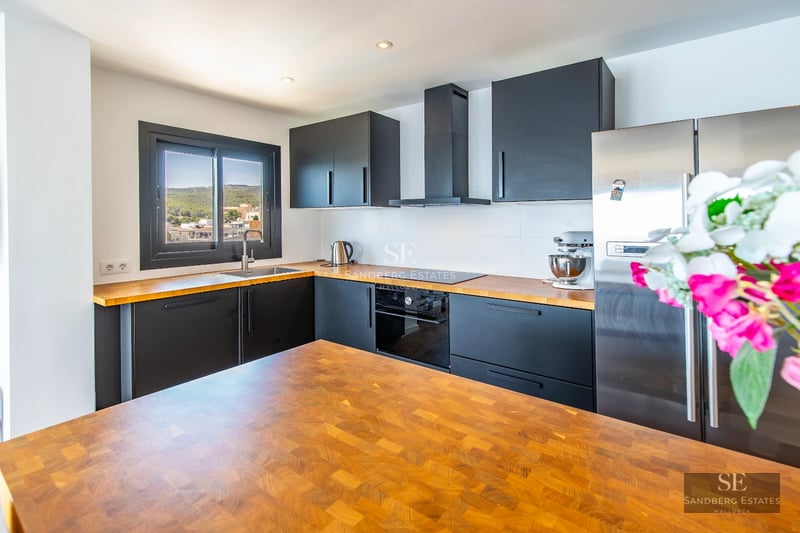 Spacious balcony with panoramic sea views. Modern outdoor furniture, wooden floor, glass railing.