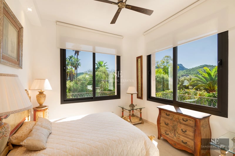 Expansive terrace with infinity pool and sea views. Modern architecture, wood flooring, designer furniture, and lush vegetation.