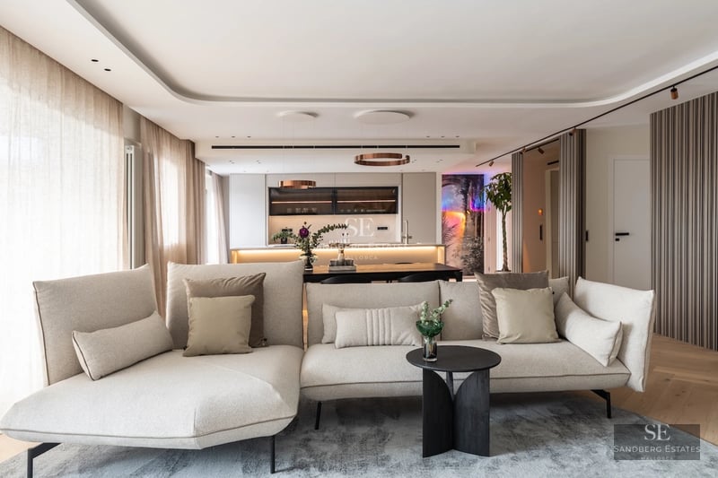 Panoramic view of modern villa with infinity pool, surrounded by gardens and large terraces. Minimalist architecture and high-end finishes.