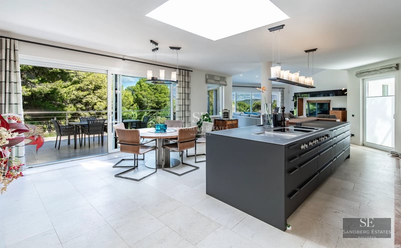 Panoramic view of an infinity pool surrounded by lush vegetation. Modern and elegant design. Warm ambient lighting.