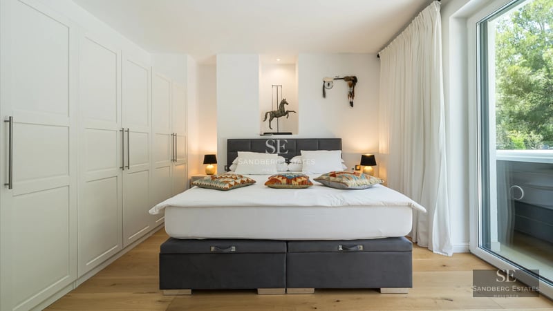 Exterior view of a modern villa featuring a pool, lush garden, and expansive terraces. Minimalist architecture with large windows.