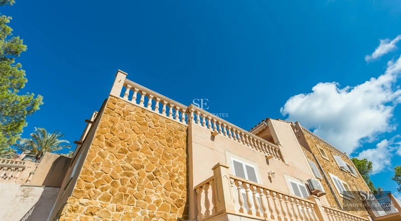 Bright living room with sea view, glazed balcony, light wood floors and minimalist modern decor.