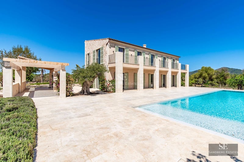 Spacious balcony overlooking the sea, modern furniture, glass railing, wooden floor, and minimalist decor.
