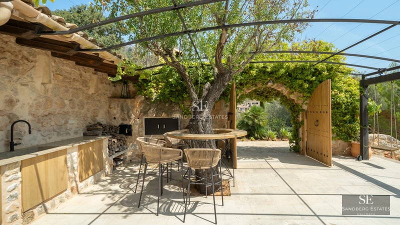 Panoramic view of infinity pool with vanishing edge, balcony with ocean views and lush vegetation.