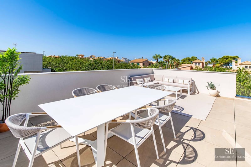 View of villa with pool. Modern architecture, large windows, covered terrace and lush garden. Warm lighting.