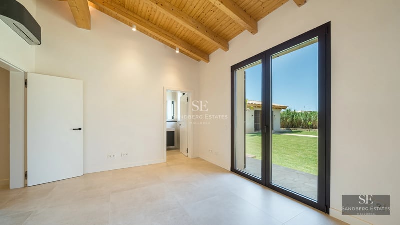 View of a modern villa with reflecting pool, large windows, and minimalist design. Lush vegetation surrounding.