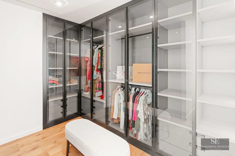 Exterior view of a modern villa with a pool, surrounded by greenery. Minimalist design with large windows and luxury finishes.