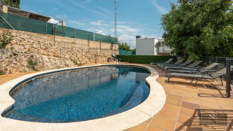 Spacious terrace with pool, sun loungers and scenic views. Modern architecture features large windows and minimalist design.