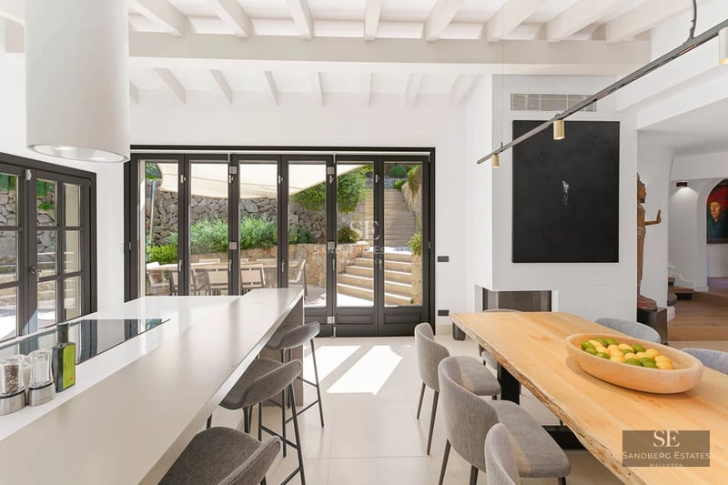 Expansive terrace with infinity pool, lounge chairs, umbrellas, and panoramic sea views. Modern and elegant design.