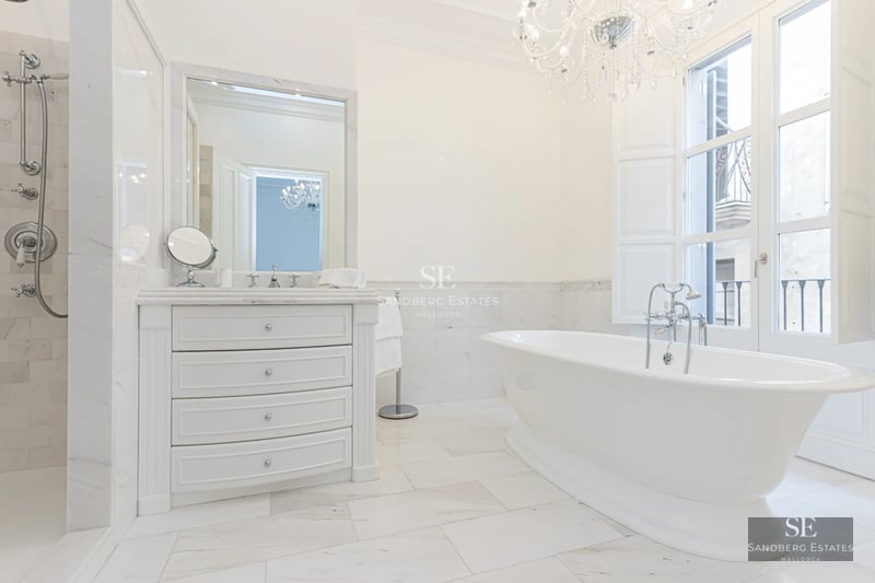 View of infinity pool with glass edge and lush garden. Modern architecture with clean lines and manicured landscaping.