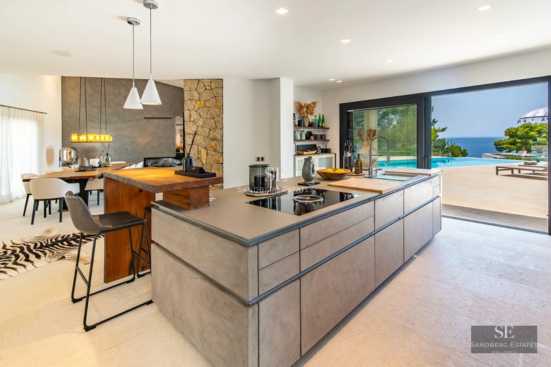 Exterior view of a modern villa featuring an infinity pool, lush greenery, and contemporary architectural design. Soft lighting and luxurious ambiance.