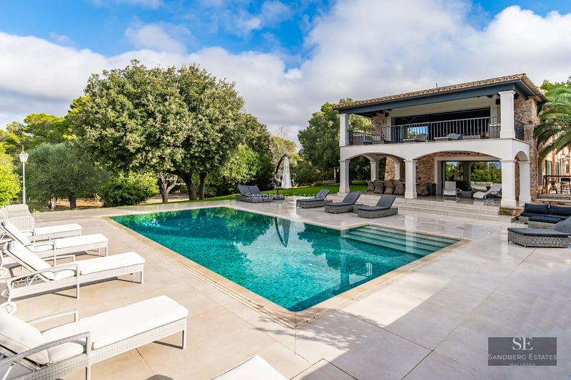 Exterior view of modern villa featuring infinity pool, expansive terraces, and lush garden. Minimalist architectural design with clean lines.