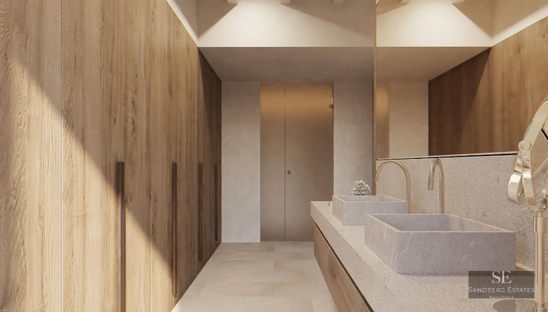 Modern bathroom featuring dual stone basins, gold faucets, and floor-to-ceiling natural wood cabinetry.