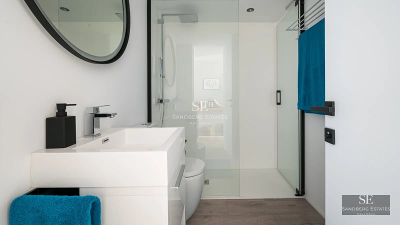 Exterior of a modern villa featuring a pool, manicured garden, and expansive windows offering stunning views.