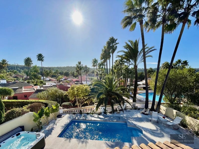 Exterior of a modern villa featuring an infinity pool, landscaped garden, and spacious terraces. Contemporary architecture with large windows.